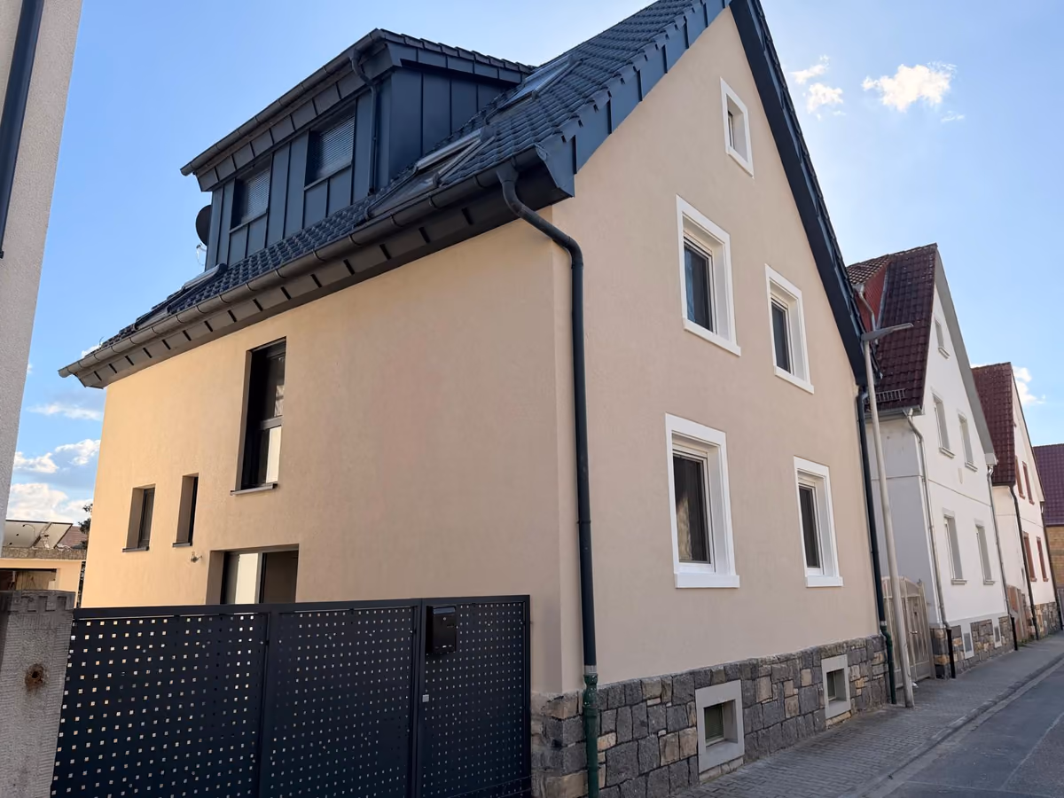 Dasselbe Wohnhaus nach den Fassadenarbeiten mit heller Fassade und weiß abgesetzten Fensterfaschen