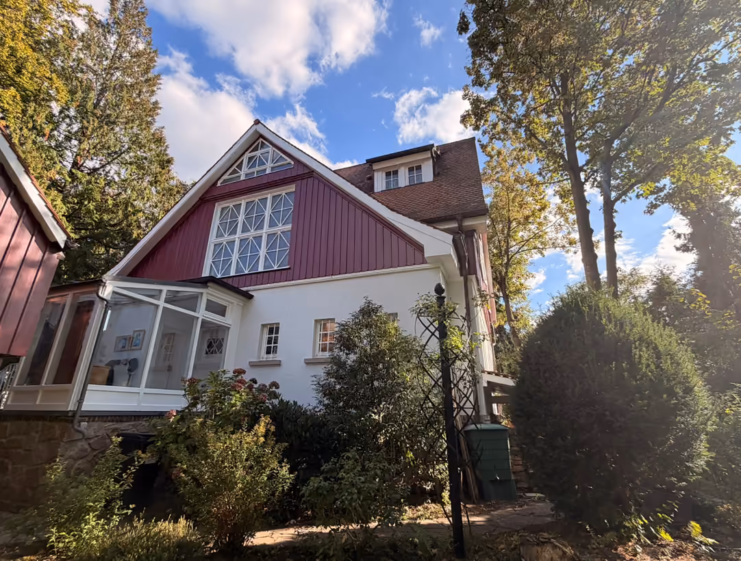 Villa mit roter Holzverschalung, weißem Putz und Wintergarten, Referenzobjekt von Patrick Noël Malerhandwerk