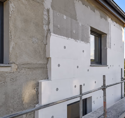 Symbolbild: Fassade mit halb angebrachten Dämmplatten